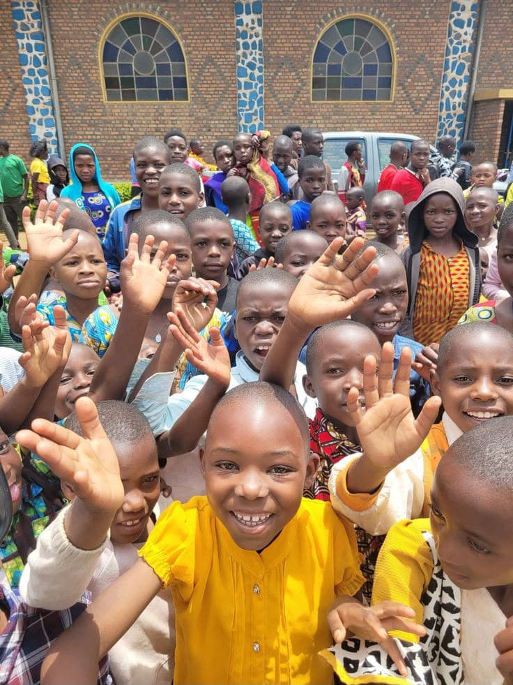 Children of the home waving and smiling at the camera